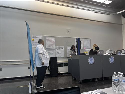man taking his license picture in front of blue screen